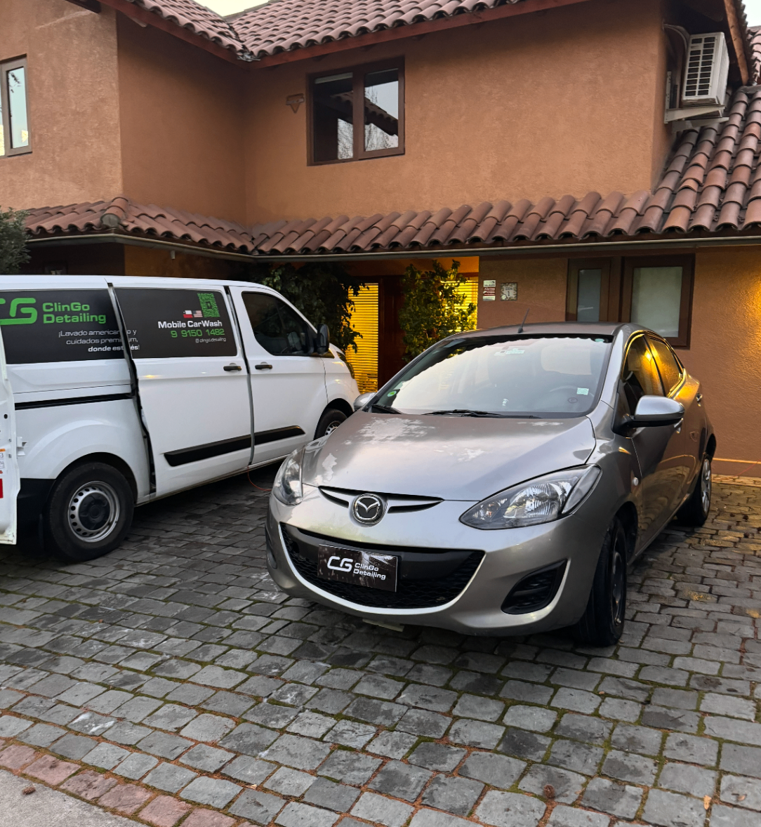 Mazda plateado atendido frente a domicilio